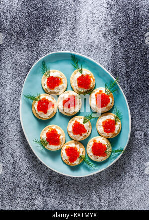 Avant-goût de caviar rouge et fromage avec de l'aneth dans une plaque bleue sur un fond en pierre Banque D'Images