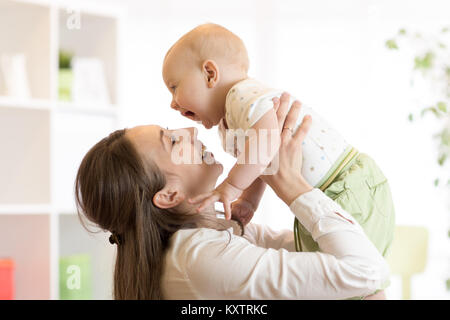 Maman et bébé positive. Jeune mère joue avec son petit fils à la maison. Banque D'Images