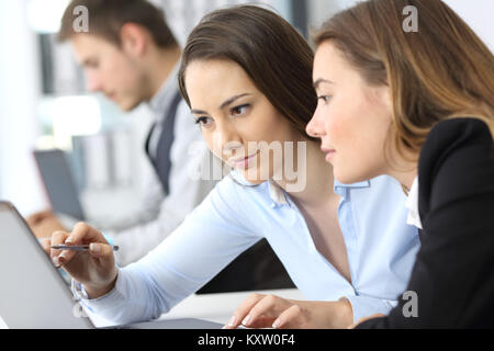 Two businesswomen working on line avec un laptop at office Banque D'Images