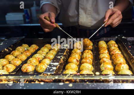 Chef japonais takoyaki cuisine, tagoyaki est le plus populaire en-cas délicieux au Japon. focus sélectif et style de film Banque D'Images