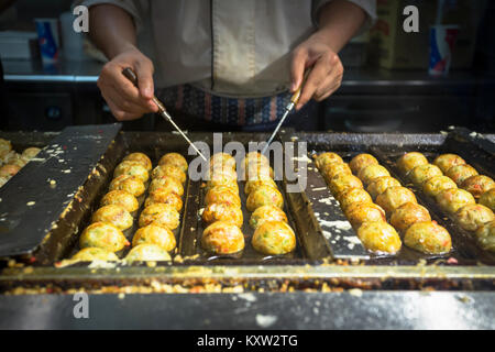 Chef japonais takoyaki cuisine, tagoyaki est le plus populaire en-cas délicieux au Japon. focus sélectif et style de film Banque D'Images