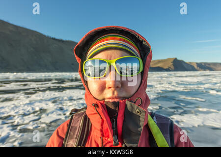 Portrait d'une femme à lunettes sur la glace du lac Baïkal. Banque D'Images