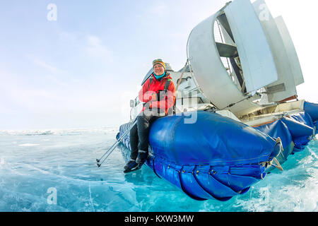 Girl est membre du conseil d'hiver glace aéroglisseur lac Baikal. Banque D'Images