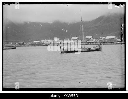 Photographie prise depuis un bateau montrant Mefjordvær dans le comté de Tromsø, en Norvège, capturant un village côtier et un paysage maritime typiques du nord de la Norvège au début du XXe siècle. Banque D'Images