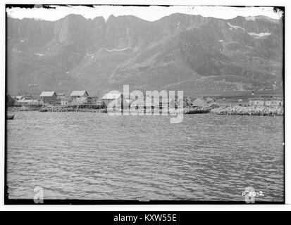 Photographie prise à partir d'un bateau représentant Mefjordvær dans le comté de Tromsø, Norvège, montrant l'architecture côtière et le cadre maritime de la région nord. Banque D'Images