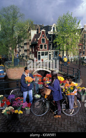 Les Pays-Bas, Amsterdam, UNESCO World Heritage Site. L'homme vente de fleurs près de canal. Âge d'or des maisons. 17e siècle. Banque D'Images