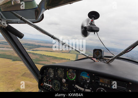 Vue depuis le cockpit d'un avion léger pendant un vol de loisirs avec des champs à l'extérieur Banque D'Images