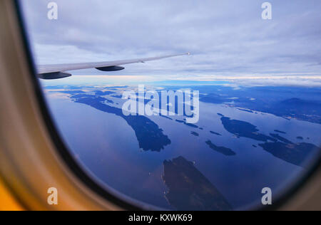 Vue depuis la fenêtre de l'avion sur les champs en haut de l'aile avec vue sur Vancouver,Canada Banque D'Images
