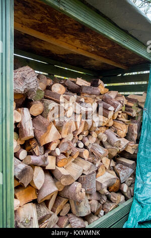 Petit bois couvert store contenant une sélection variée de bois dur et souple pour une utilisation dans la poêle. Banque D'Images