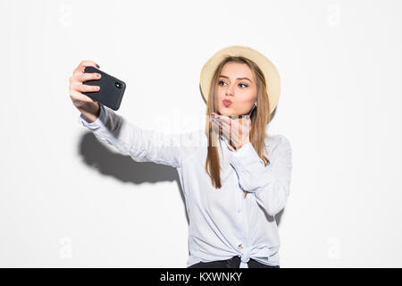 Woman in hat faire baiser sur camera coup selfies isolated on white Banque D'Images