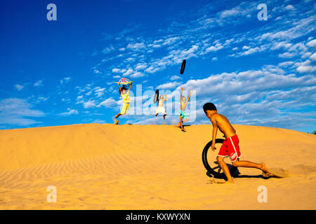 Enfants jouant dans les dunes de sable près de Phan Rang, le centre du Vietnam Banque D'Images