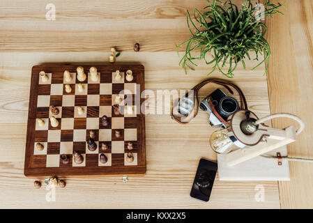 Voir ci-dessus de l'ensemble du conseil d'échecs avec de vieux vintage camera on wooden table Banque D'Images