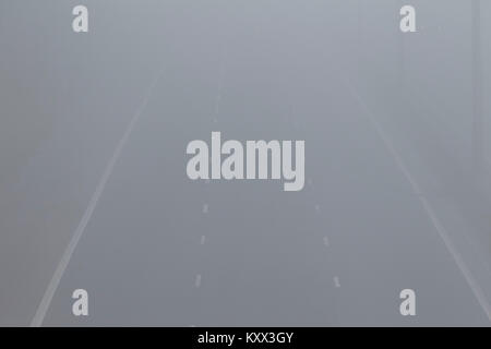 Voiture à l'aide d'foglight dans la distance de la conduite sur autoroute en un jour brumeux au Royaume-Uni Banque D'Images