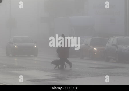 Personne qui marche dans la rue au croisement de chien on foggy Day au Royaume-Uni Banque D'Images