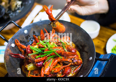 Baguettes en tenant les écrevisses des écrevisses épicée pot sur la table Banque D'Images
