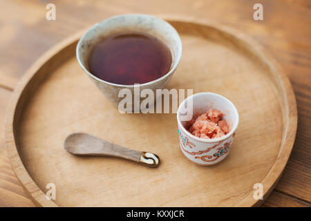High angle close up de bol de soupe miso, bol de gingembre écrasé et cuillère en bois sur un plateau. Banque D'Images