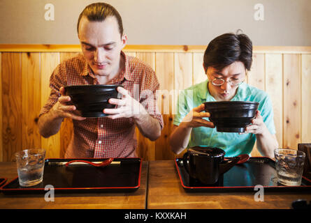 Deux personnes dans un café avec des bols de nouilles de soba. Un homme de l'ouest et d'un homme japonais. Banque D'Images