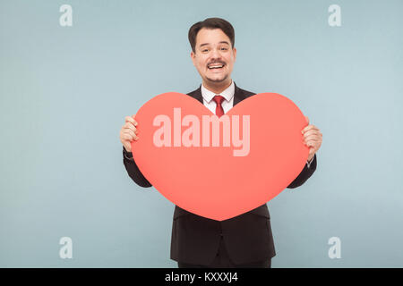 Lovely woman big red heart shape et souriant. Studio shot, isolé sur fond bleu clair Banque D'Images