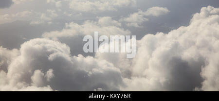 Les nuages blancs et gris sur fond de ciel bleu foncé. Photo aérienne de la fenêtre de l'avion Banque D'Images