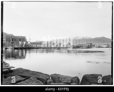 Une photographie historique montrant le port de Fosnavåg dans le comté de Møre og Romsdal, en Norvège, prise entre 1900 et 1910, représentant des navires amarrés au bord de l'eau, les bâtiments environnants et le cadre insulaire-ville où l'activité maritime était importante. Wikimedia Commons+2Wikipédia+2 Banque D'Images