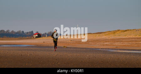 Runner sur plage de carrossage en hiver le soleil. Banque D'Images