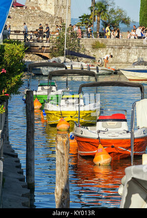 Trois bateaux colorés amarrés à la marina de Sirmione, Lac de Garde, Italie Banque D'Images