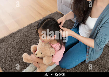 High angle view la photo d'une femme petite fille de tressage de cheveux. Banque D'Images