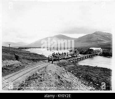 Le 17 juillet 1906, le premier train de voyageurs franchit le pont de la rivière Nome sur le Seward Peninsula Railway à Nome, en Alaska, marquant une étape importante dans le développement des transports en Alaska. Banque D'Images