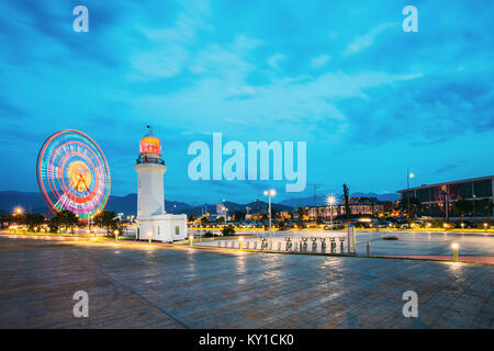 Batumi, Géorgie, l'Adjarie. Grande roue en mouvement et Pitsunda Phare à la promenade dans le parc d''Attractions, Miracle City Park sur bleu ciel du soir et Hill Banque D'Images