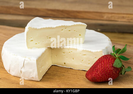 La roue des fromages brie avec triangle découper et fraise. Banque D'Images