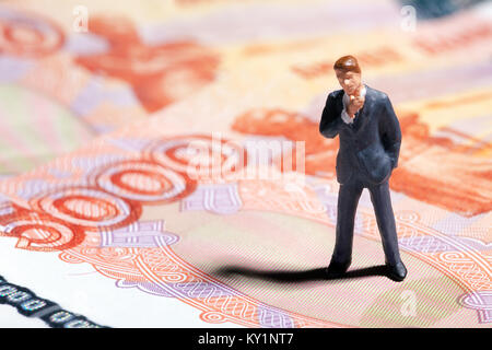 Figurine miniature businessman with 5000 roubles billet sur arrière-plan Banque D'Images