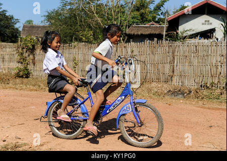 La province de Vientiane, Laos village Tham , deux jeunes filles venant de l'école en vélo / Kinder kommen mit dem Fahrrad von der Schule Banque D'Images