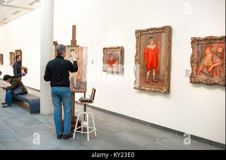 Homme peinture photo, vue d'un homme copie une peinture d'Auguste Renoir intitulée Claude Renoir en Clown dans le Musée de l'Orangerie à Paris, France. Banque D'Images