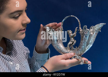 Londres, Royaume-Uni. 12 janvier 2018. Une femme regarde un vase de fleurs d'argent à l'occasion de la London Art Antiquités & Interiors juste à Excel London 12 au 14 janvier 2018. 100 marchands spécialisés sont mettant en vedette plus de 30 000 articles du classique au contemporain. Crédit : Stephen Chung / Alamy Live News Banque D'Images