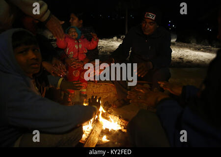 Katmandou, Népal. 12Th Jan, 2018. Les gens s'asseoir à côté d'un feu pour se réchauffer en hiver sur la périphérie de Katmandou, Népal le Vendredi, Janvier 12, 2018. Credit : Skanda Gautam/ZUMA/Alamy Fil Live News Banque D'Images