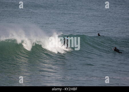 Newquay, Cornwall, UK. 12Th Jan, 2018. Du beau temps et de grosses vagues, faire ressortir les surfeurs sur la côte nord des Cornouailles. Le surf le temps était limité dans les eaux glaciales. Credit : Nicholas Burningham/Alamy Live News Banque D'Images