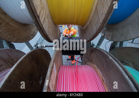 Buchen, Allemagne. 12Th Jan, 2018. Un spécialiste pour l'installation de la fibre optique démontre comment un câble à fibres optiques est tiré par un tambour de câble au cours de l'événement de clôture du projet "internet haute vitesse dans le district de Neckar-Odenwald' à Buchen, Allemagne, 12 janvier 2018. Videz les conduites sont enroulées autour du câble autour de la batterie. Credit : Marijan Murat/dpa/Alamy Live News Banque D'Images