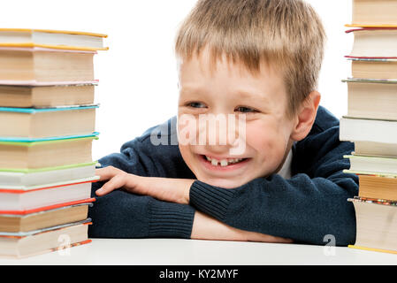 Portrait d'un écolier rire close-up parmi une pile de livres Banque D'Images