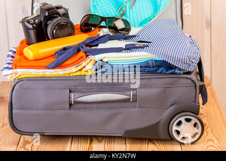 Une valise remplie de choses pour des vacances à la mer Banque D'Images