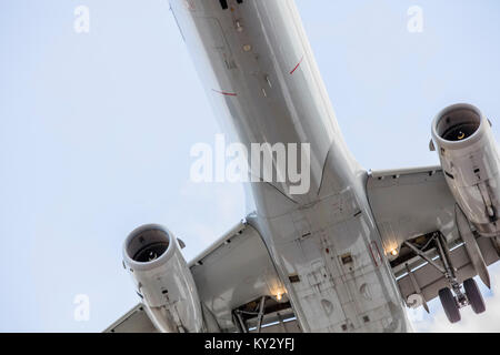 Jet commercial de passagers à l'atterrissage comme vu du dessous de l'avion. Descente du train d'atterrissage Banque D'Images