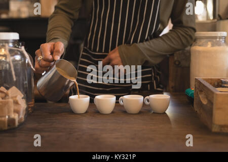 Barista pouring coffee en tasses au comptoir Banque D'Images