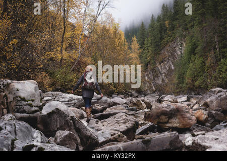 Femme marche sur les rochers en forêt d'automne Banque D'Images