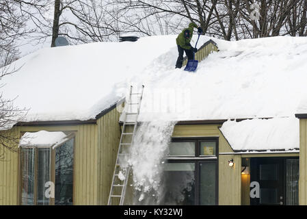 Un homme déblayer la neige du toit d'une maison, la ville de Québec en hiver Banque D'Images