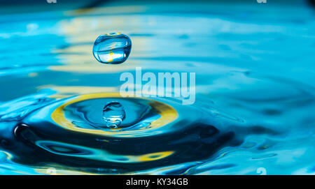Goutte d'eau dans un verre de couleur bleue Banque D'Images