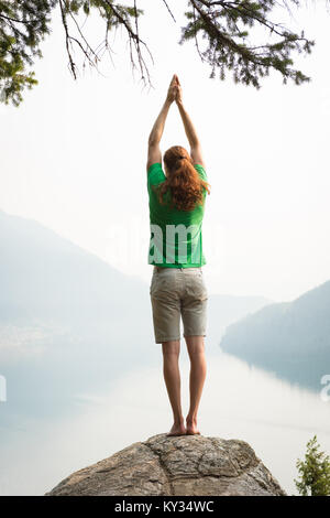 Fit man performing exercice s'étendant sur le bord d'un rocher Banque D'Images