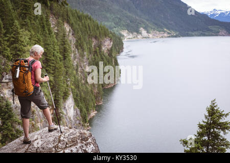 Mature Woman standing on rock Banque D'Images