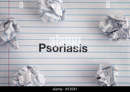 Le psoriasis. Mot Psoriasis sur feuille portable avec quelques boules de papier froissé sur elle. Close up. Banque D'Images