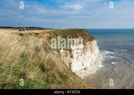 Tracteur travaillant dans les champs à falaise Flamborough Head, North Yorkshire, Angleterre. Banque D'Images