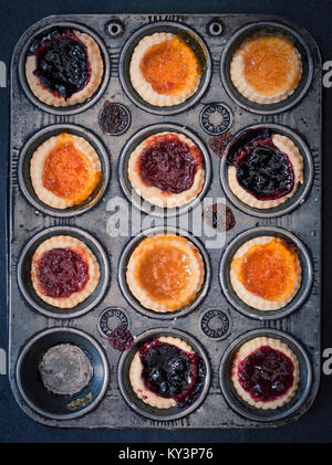 Tartelettes à la confiture faite maison cuit dans une plaque de cuisson sur ardoise. Vintage filtre appliqué Banque D'Images