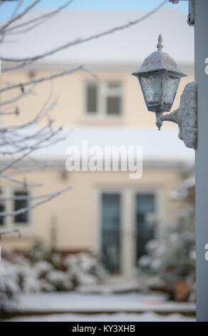 Un coup d'hiver lumineux de la capture d'un style traditionnel coach extérieur lanterne couverte de neige. Soft-focus contexte montre bien couverte de neige et jardin. Banque D'Images